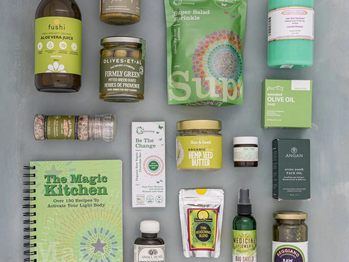 A Raw Living trade flatlay of green wholefoods, aloe vera juice, salad sprinkle and natural skincare